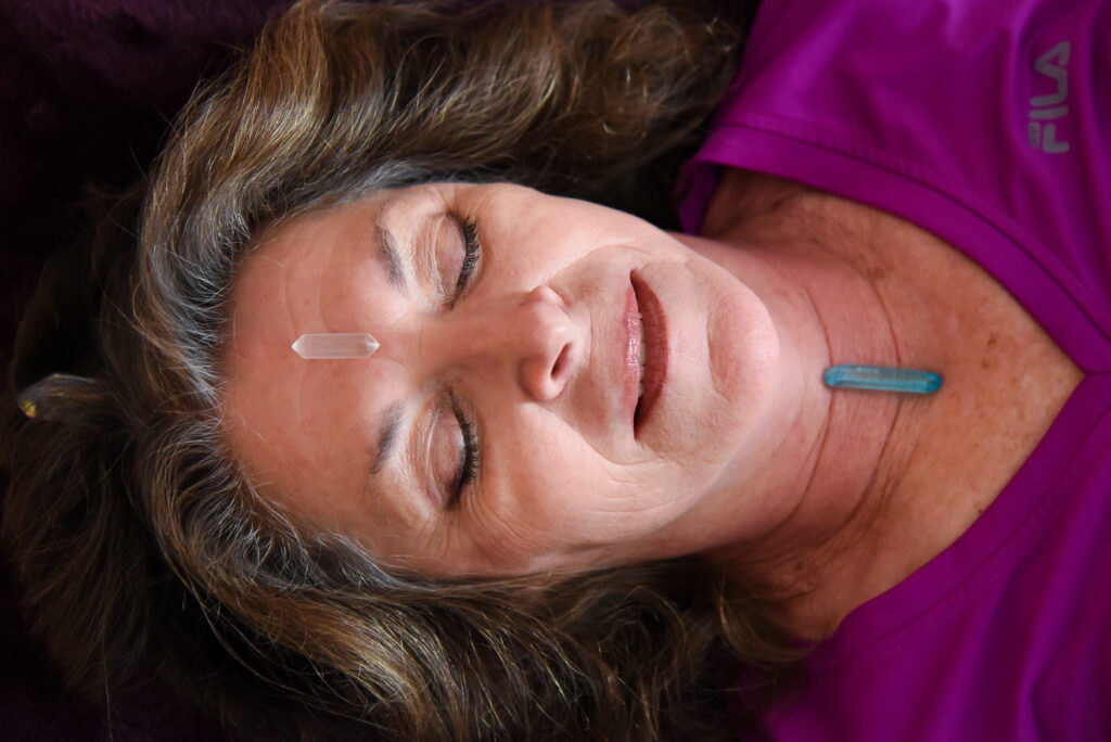 crystal healing reiki healing in denver. lady with facial and crystals at garnet moon.